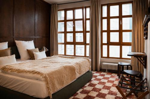 a bedroom with a large bed and large windows at The Charming by Curt Suites in Berlin