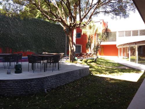 a patio with tables and chairs in a yard at Hotel Boutique Abad in Guadalajara