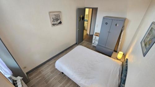 a small bedroom with a bed and a blue cabinet at Appart hôtel Roanne hyper centre ville in Roanne