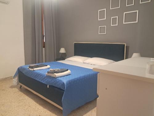 a bedroom with a blue bed with towels on it at Marina Serra in Marina Serra