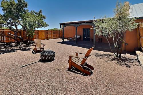 a patio with two chairs and a grill and a house at Five Ravens in Santa Fe