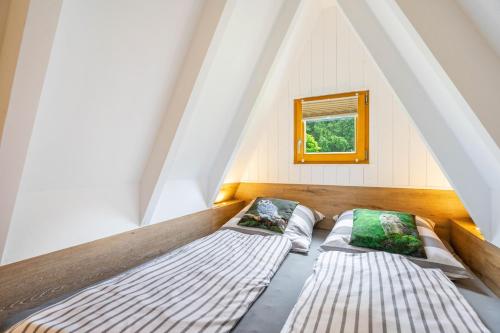 two beds in a room with a window at Ferienhaus Eulennest in Billerbeck