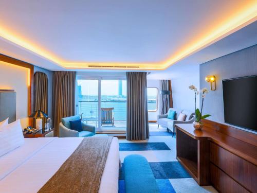a hotel room with a bed and a flat screen tv at Queen Elizabeth 2 Hotel in Dubai