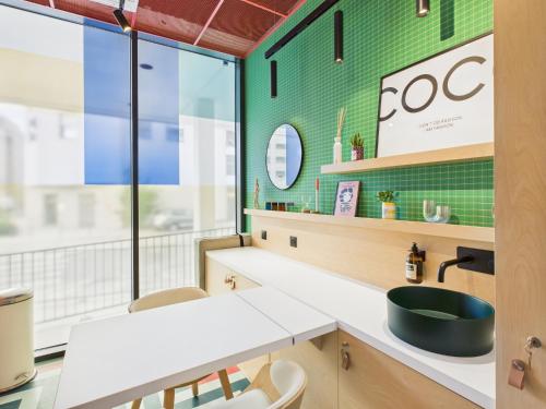 a bathroom with a sink and a green wall at Hife Bordeaux in Bordeaux