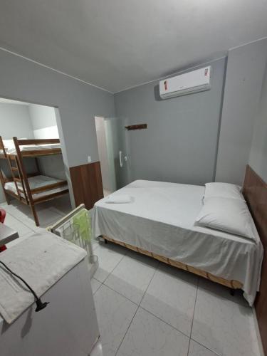 a bedroom with a bed and a chair in it at Hotel e Pousada REQUINTTE in Parnaíba