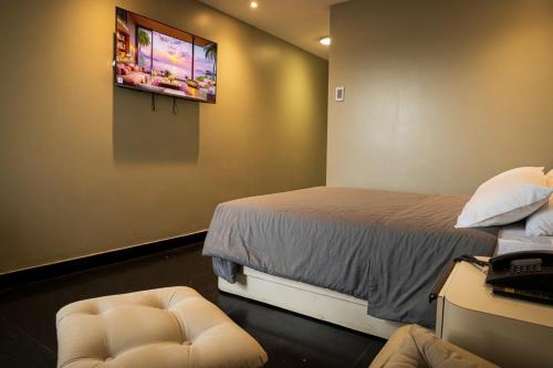 a room with two beds and a tv on the wall at Hotel Camino Real Valera in Valera