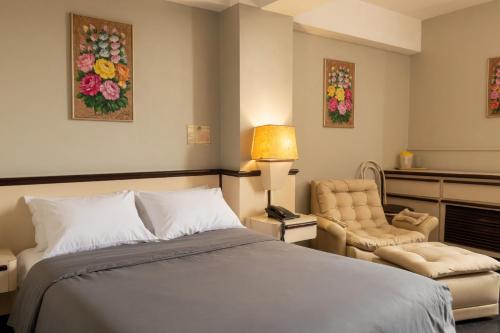 a bedroom with a bed and a chair at Hotel Camino Real Valera in Valera