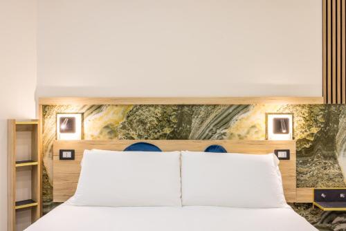 a bedroom with a white bed and a painting on the wall at Partenope Rooms in Naples