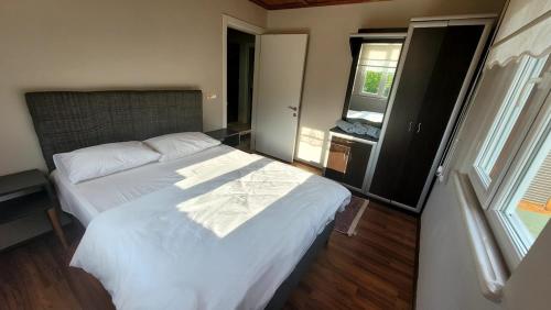 a bedroom with a large white bed and a window at Umut Konaklama in Ardeşen