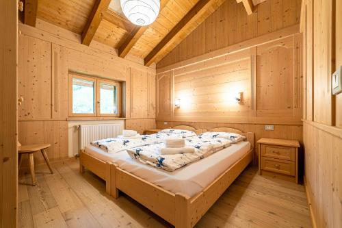 a bedroom with a bed in a wooden cabin at Ciesa Al Drago in Rocca Pietore