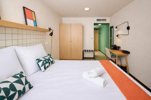a bedroom with a white bed and a desk at Hife Bordeaux in Bordeaux