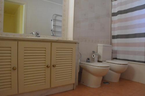 a bathroom with a toilet and a sink and a mirror at Cabanas de Tavira Apartment in Cabanas de Tavira
