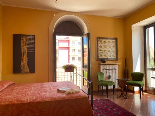 a bedroom with a bed and two green chairs at Dimora al Borgo Antico in Isernia