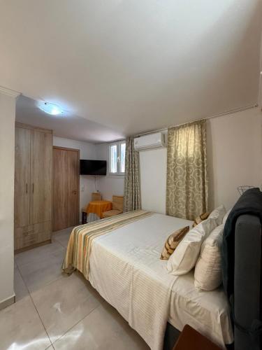 a bedroom with a large white bed in a room at Rodon Apartments in Tsoukalades