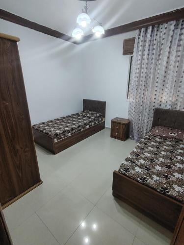 a room with two beds and twounks in it at شقة سرايا in Irbid