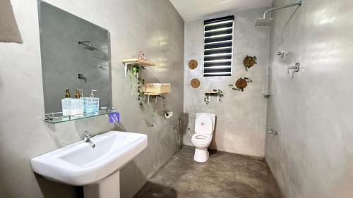 a bathroom with a sink and a toilet at Villa Tropical Oasis in Balapitiya