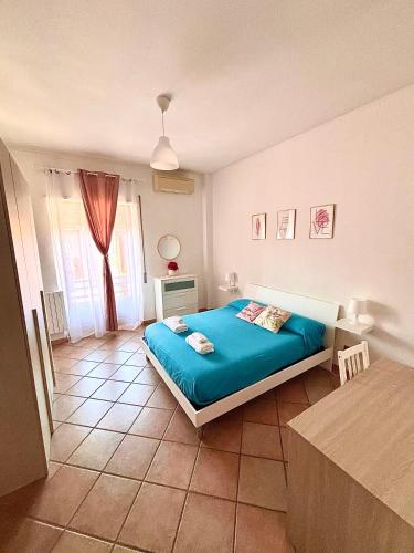 a bedroom with a blue bed and a window at La Dolce Vita in Bracciano