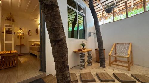 a living room with a palm tree and a chair at White Maakana Lodge Maldives - all inclusive ed escursioni incluse ogni giorno in Felidhoo 