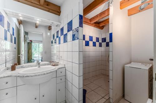 a bathroom with a sink and a washer and dryer at Appartement 6 p Sanguinet-"Chott" in Sanguinet