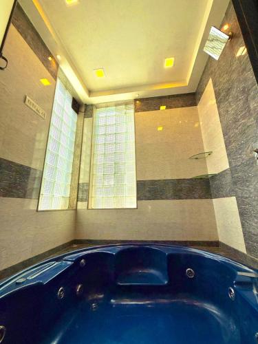 a large blue tub in a room with a window at Aashiayana Villa - The Dream Stays ll Big Pvt Pool ll 3 Ac rooms ll Wi-fi in Lonavala