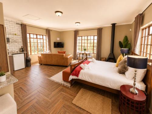 a bedroom with a large bed and a living room at Amber Collection in Dullstroom