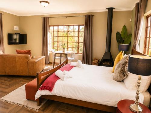 a bedroom with a bed and a living room at Amber Collection in Dullstroom