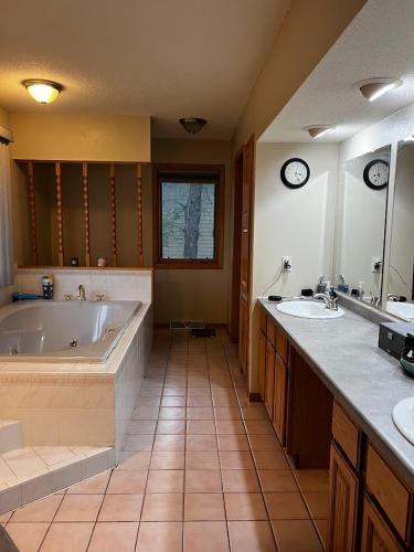 a large bathroom with a tub and two sinks at The Fairway Escape in Hayward
