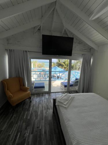a bedroom with a bed and a tv and a chair at El Tridente in Juan Dolio