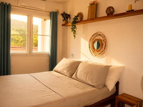 a bedroom with a bed with a window and a mirror at Hiraya Apartments in San Vicente