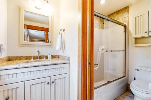 a bathroom with a toilet and a sink and a shower at Lakefront At Winnipesaukee in Gilford