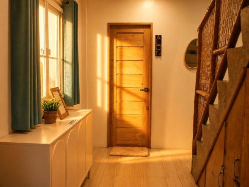 a hallway with a wooden door and a window at Hiraya Apartments in San Vicente