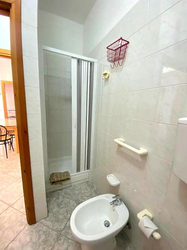 a white bathroom with a toilet and a shower at Bentu e Soli Home Holiday in Villasimius