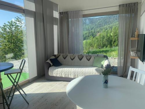 a living room with a couch and a large window at B&B Tantané in Torgnon