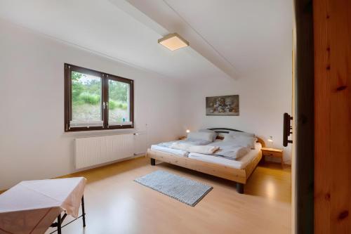 a bedroom with a bed and a window at Ferienwohnung Sensweiler Mühle in Sensweiler
