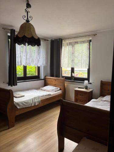 a bedroom with two beds and two windows at Zajazd pod Chmurką in Rabka-Zdrój