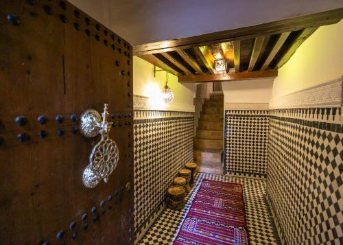 a hallway with a room with a tile floor and a door at Riad Lile Fes in Fez