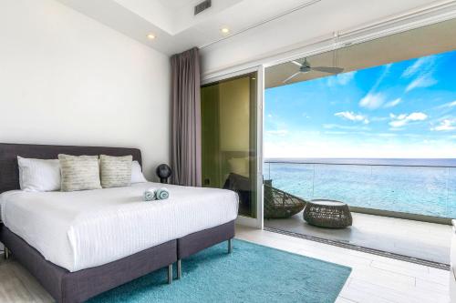 a bedroom with a bed and a view of the ocean at Lighthouse Point Residences in West Bay