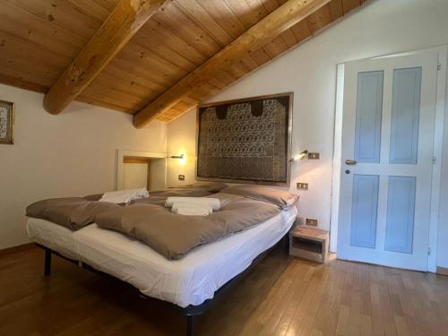a large bed in a room with a wooden ceiling at Chalet Monciòn in Rualp