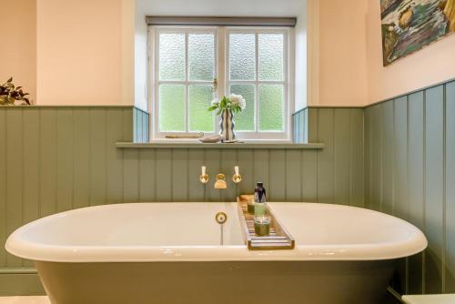 a bath tub in a green bathroom with a window at 5 Bed in Church Stretton oc-t30413 in Church Stretton