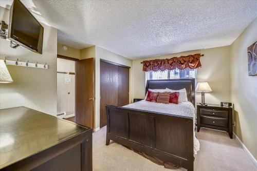 a bedroom with a bed with a dresser and a window at Longbranch 214 in Breckenridge