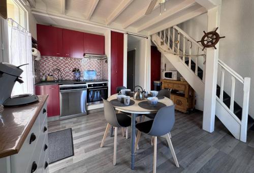 a kitchen with a table and chairs and a staircase at 4HTAMA5-Charmante maisonnette avec terrasse in Le Barcarès