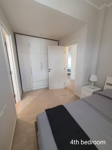 a white bedroom with a bed and a closet at Almaza bay Beach Town Chalet in Marsa Matruh