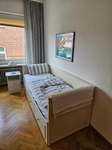 a small bed in a room with a window at City Apartment in Bad Arolsen