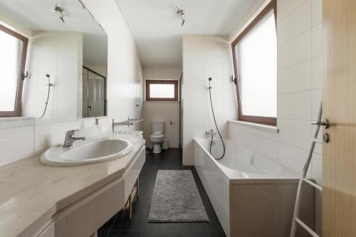 a bathroom with two sinks and a tub and a toilet at Vila Moleza in Vau