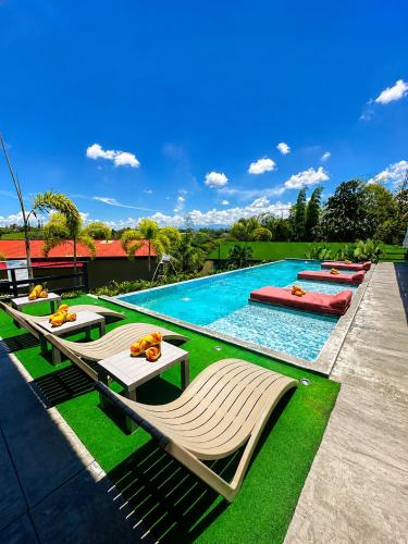a swimming pool with chaise lounge chairs and a resort at Eco Hotel La Colina Mirador Con aire acondicionado in Quimbaya