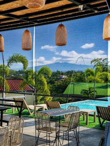 a patio with a table and chairs and a pool at Eco Hotel La Colina Mirador Con aire acondicionado in Quimbaya