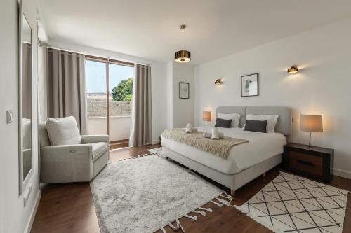 a bedroom with a bed and a chair and a window at Vila Moleza in Vau