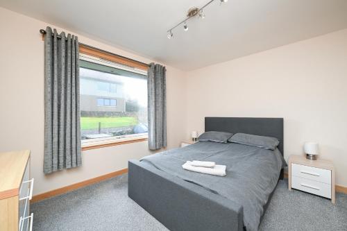 a bedroom with a bed and a large window at Soundview in Lerwick
