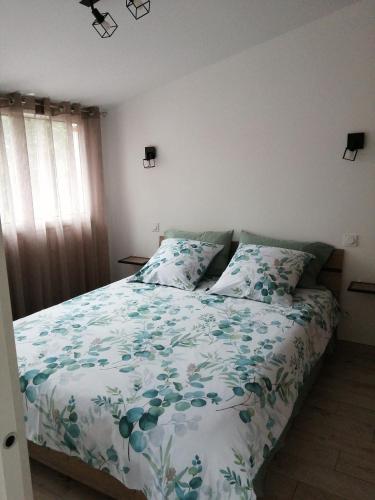 a bedroom with a bed with a green and white comforter at Askatasuna in Itxassou