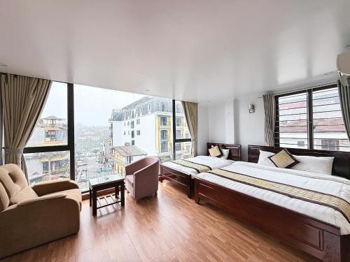 a bedroom with two beds and a large window at Sweden SaPa Hotel in Sapa